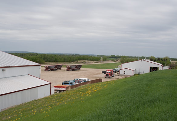 View of white buildings and red truck from green grass hill